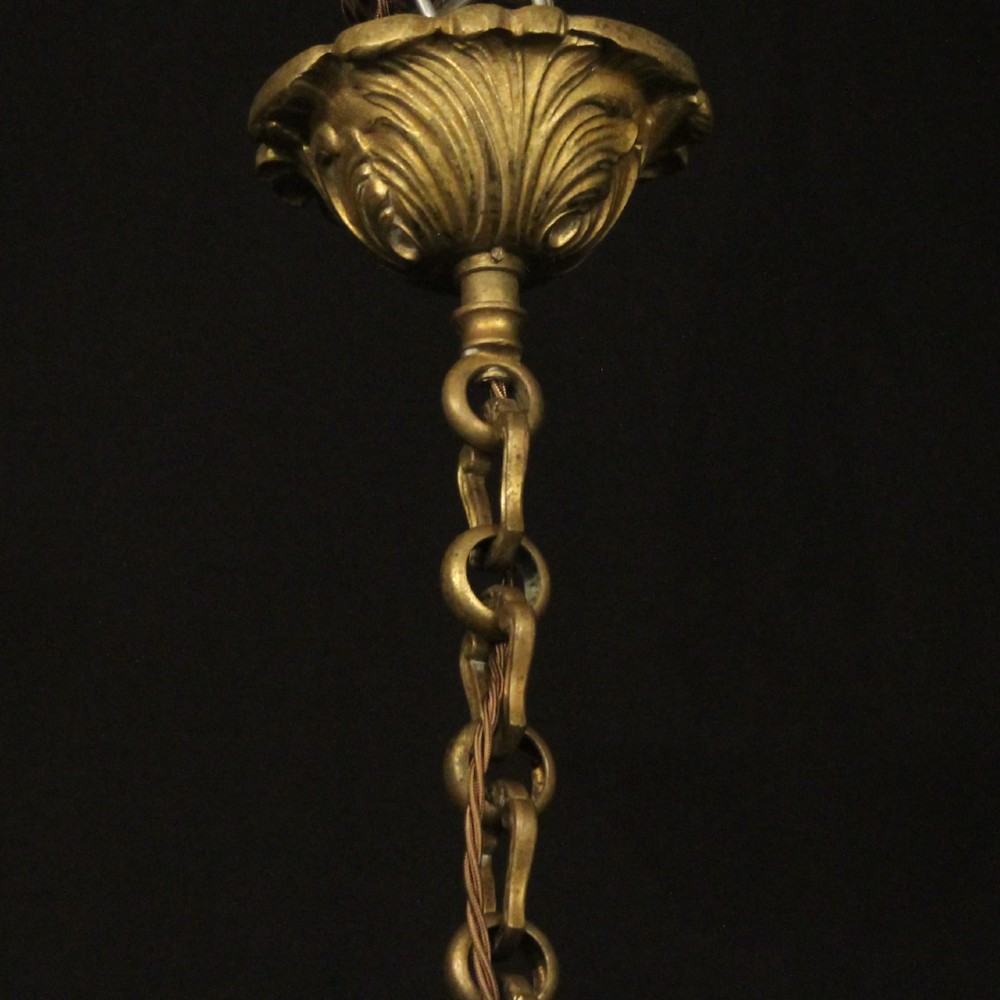 A six-arm French gilt bronze chandelier featuring scrolled arms, leaf motifs, and faux candle bulb holders hanging from a central column. View X