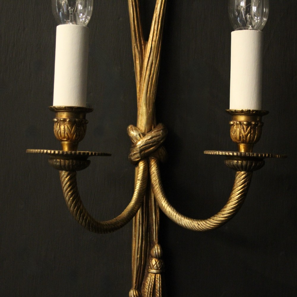 A pair of French gilded brass twin-arm wall sconces featuring a tied rope and tassel motif with candle-style bulb fittings. View IV