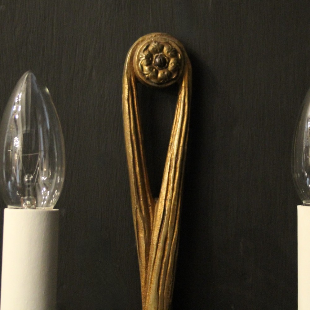 A pair of French gilded brass twin-arm wall sconces featuring a tied rope and tassel motif with candle-style bulb fittings. View VI
