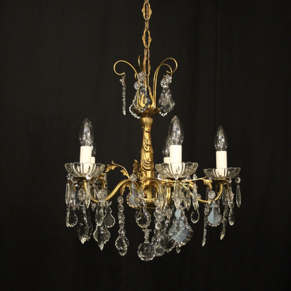 A French gilded metal five-arm chandelier decorated with hanging cut-crystal teardrop pendants and clear glass drip pans.