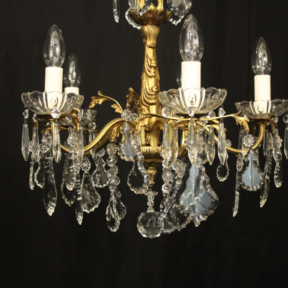 A French gilded metal five-arm chandelier decorated with hanging cut-crystal teardrop pendants and clear glass drip pans. View II