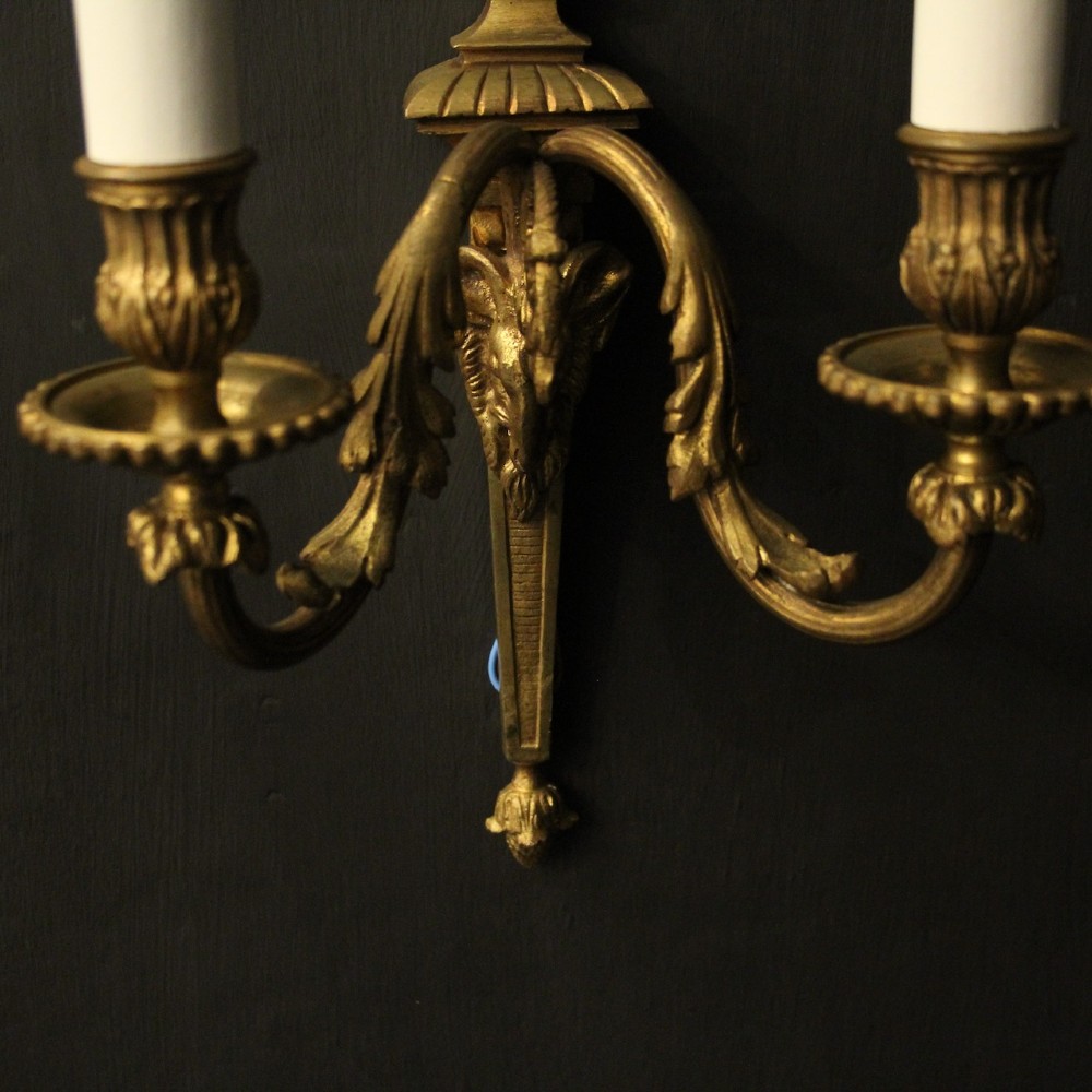 A pair of antique gilded bronze two-arm wall lights decorated with central urn finials and acanthus leaf scroll branches. View V