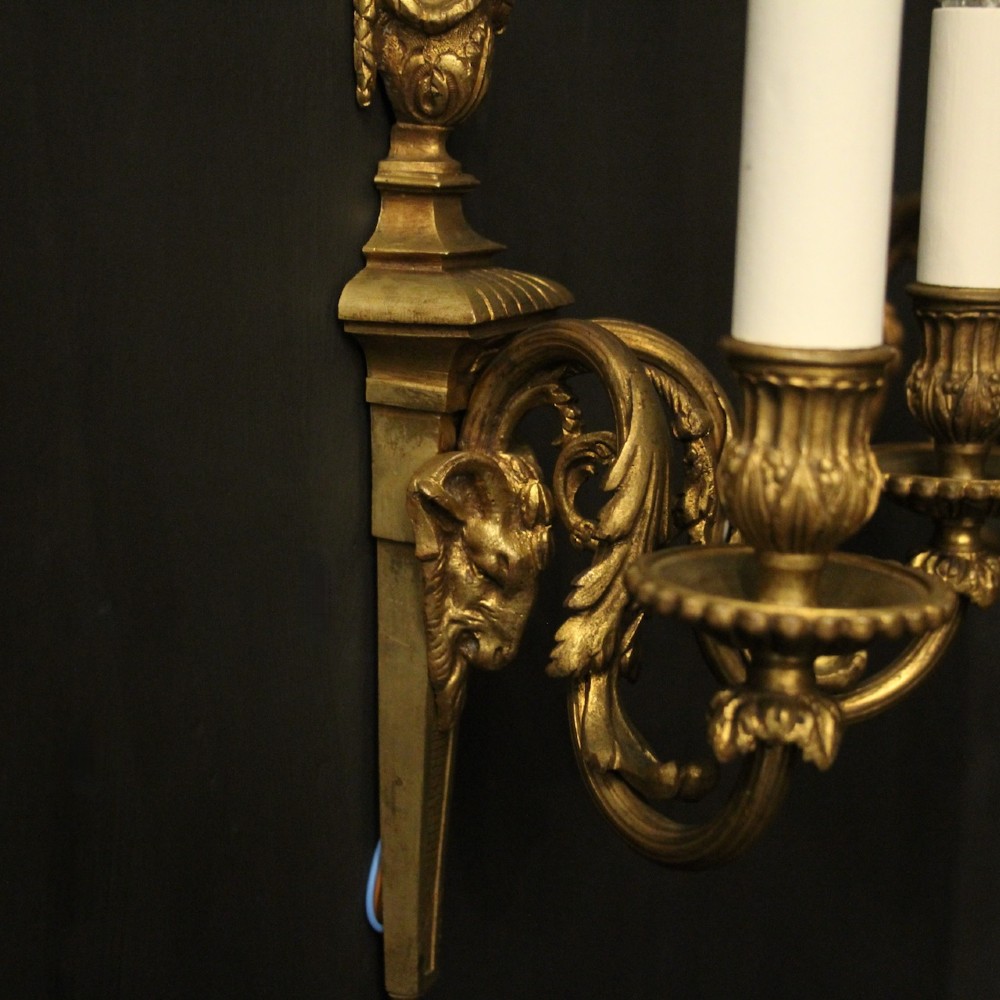 A pair of antique gilded bronze two-arm wall lights decorated with central urn finials and acanthus leaf scroll branches. View VII