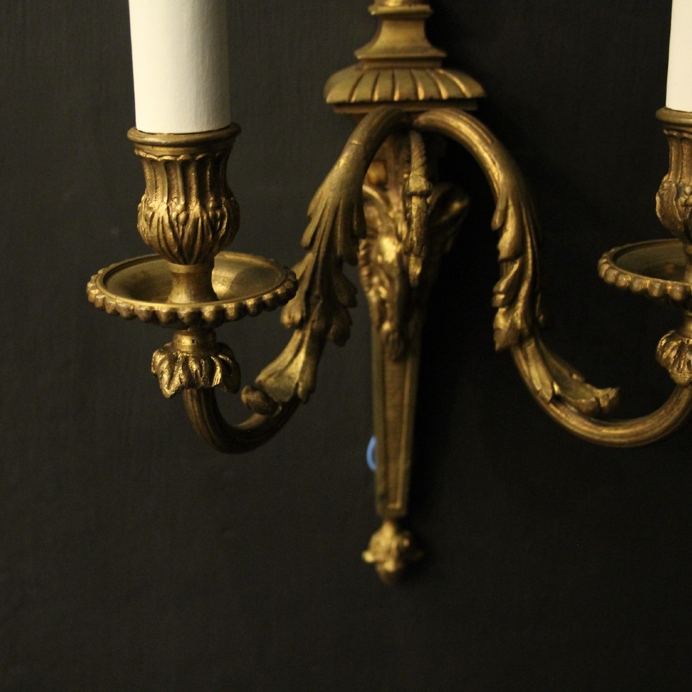 A pair of antique gilded bronze two-arm wall lights decorated with central urn finials and acanthus leaf scroll branches. View VIII