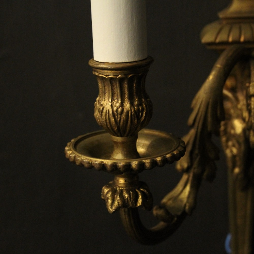 A pair of antique gilded bronze two-arm wall lights decorated with central urn finials and acanthus leaf scroll branches. View IX
