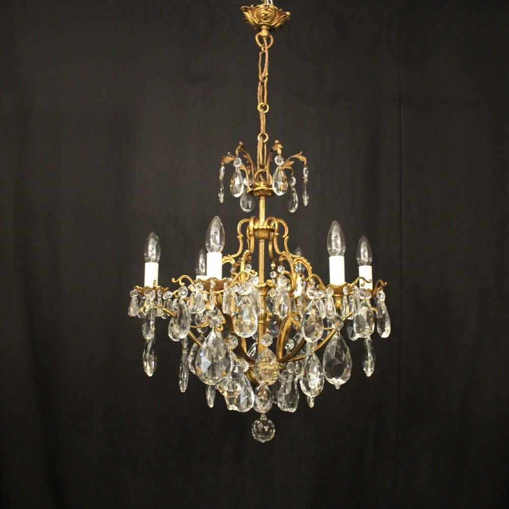 A six-light French gilded metal chandelier decorated with faceted crystal drops and hanging glass pendants.