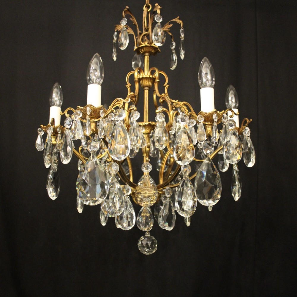 A six-light French gilded metal chandelier decorated with faceted crystal drops and hanging glass pendants. View II