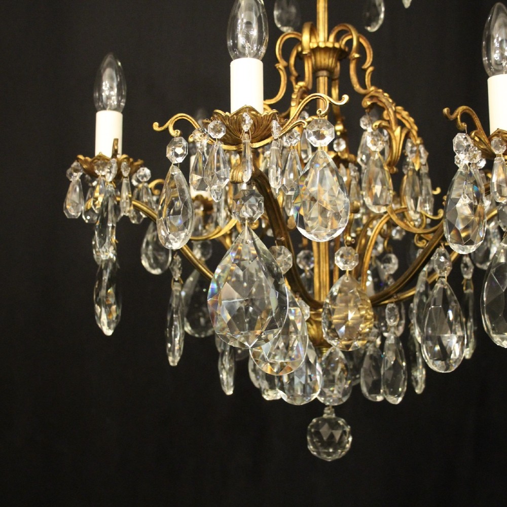 A six-light French gilded metal chandelier decorated with faceted crystal drops and hanging glass pendants. View IV