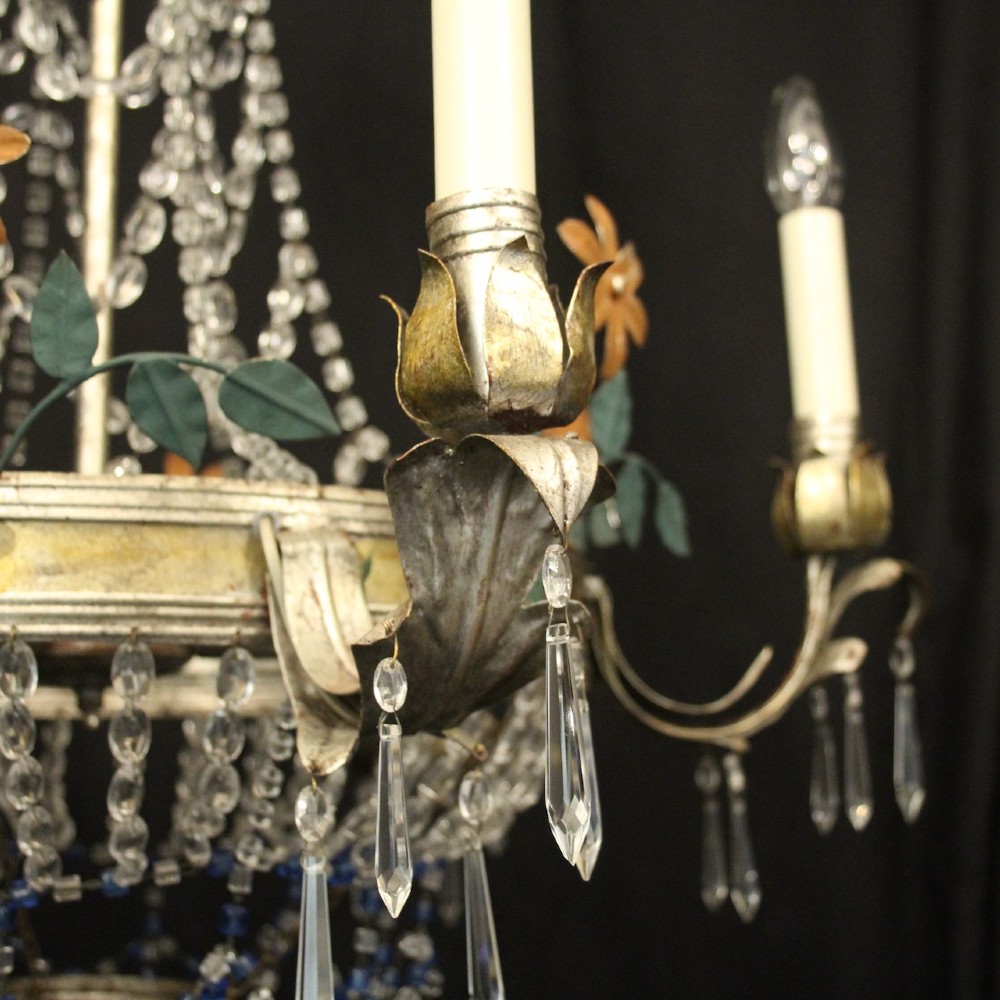 A French tent and waterfall chandelier featuring a silver-gilded frame with floral accents, layered crystal bead strands, glass drops, and six candle light sockets. View V