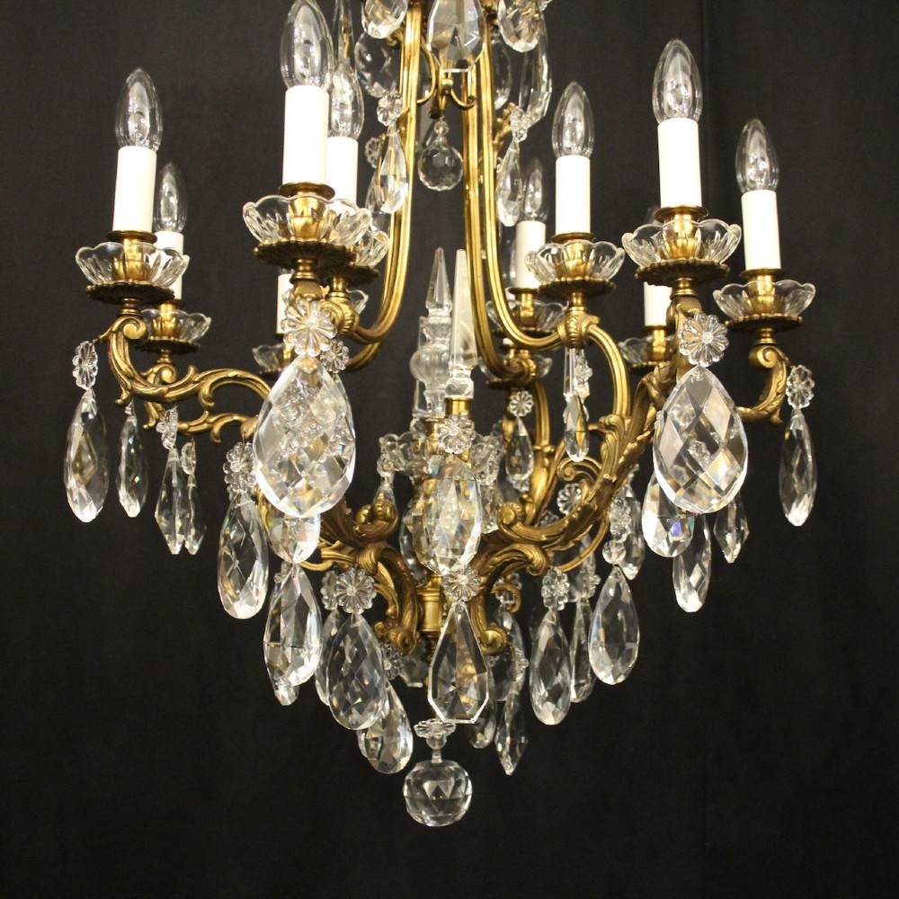 A French gilded bronze cage chandelier featuring scrolled arms, candle-style bulb holders, and hanging cut crystal drops. View II