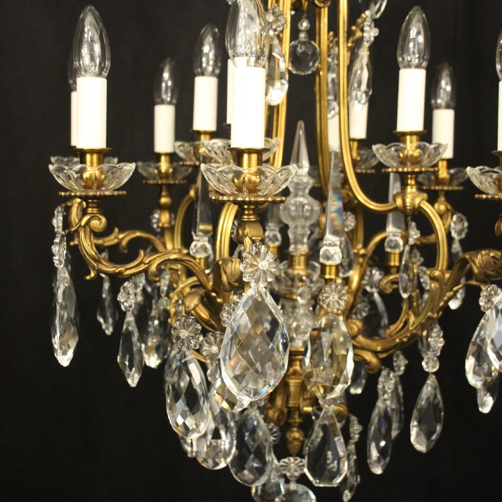 A French gilded bronze cage chandelier featuring scrolled arms, candle-style bulb holders, and hanging cut crystal drops. View III