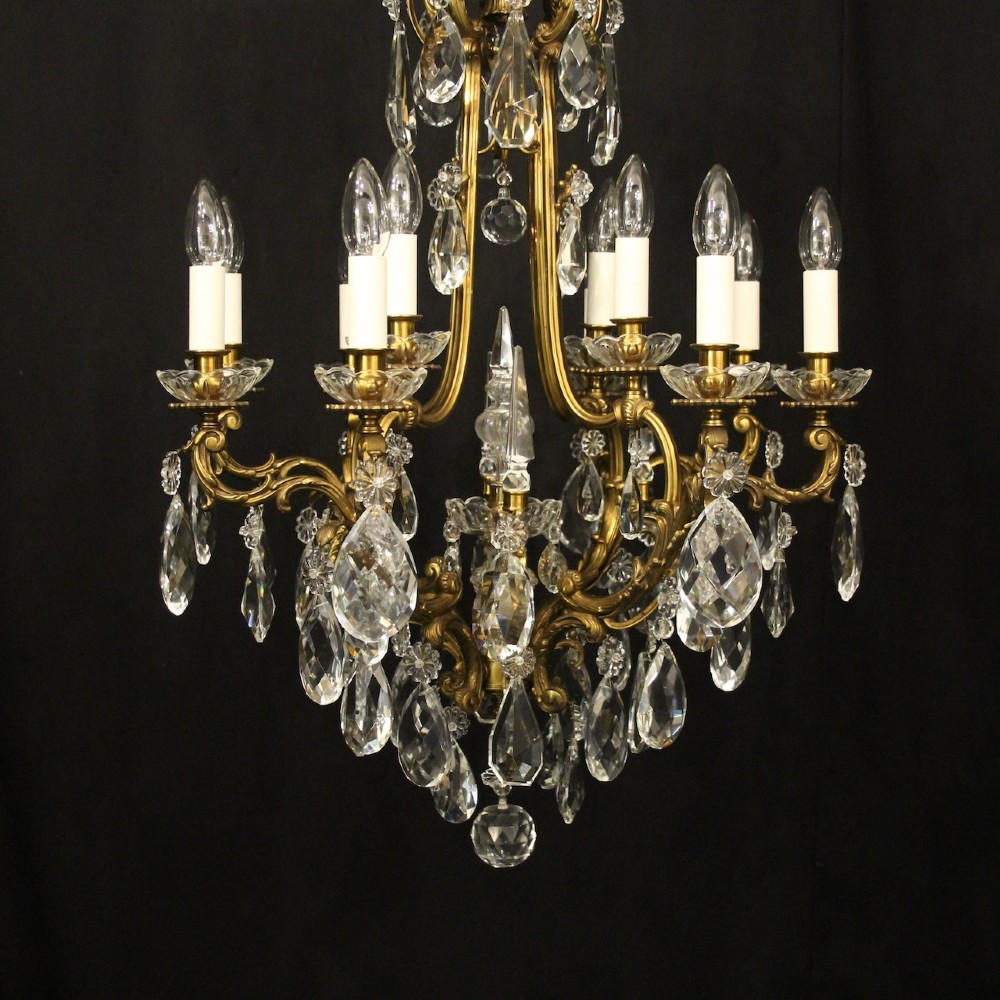A French gilded bronze cage chandelier featuring scrolled arms, candle-style bulb holders, and hanging cut crystal drops. View VII