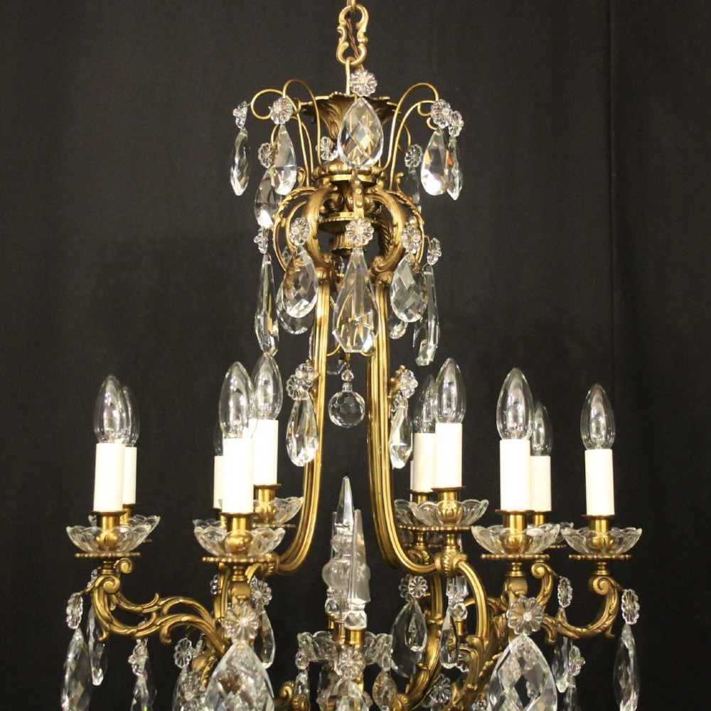 A French gilded bronze cage chandelier featuring scrolled arms, candle-style bulb holders, and hanging cut crystal drops. View VIII