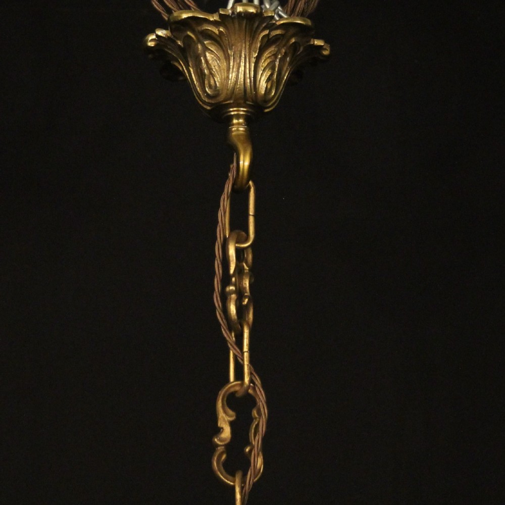 A French gilded bronze cage chandelier featuring scrolled arms, candle-style bulb holders, and hanging cut crystal drops. View X