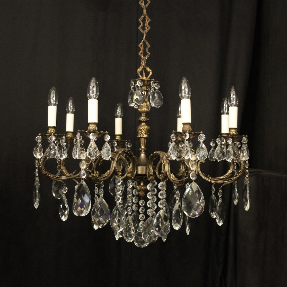 A pair of antique French eight-light brass chandeliers featuring scrolled arms and cut crystal teardrop prisms. View II