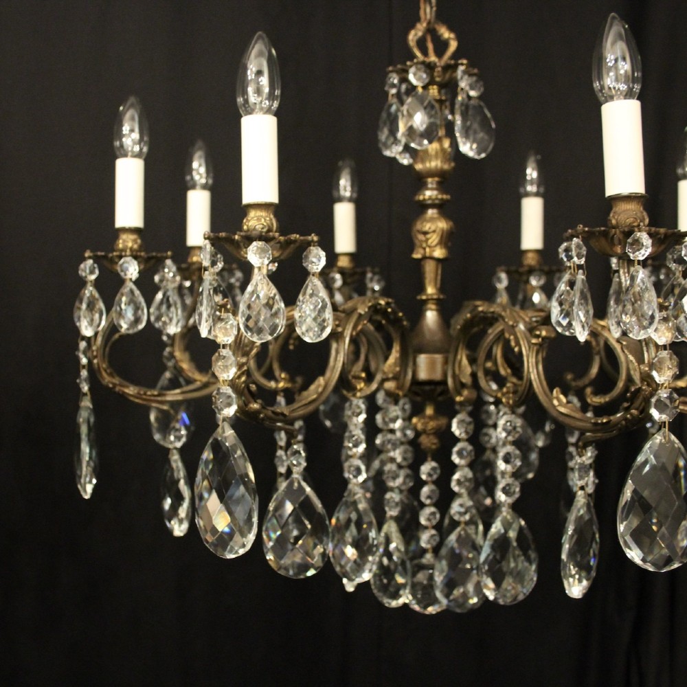 A pair of antique French eight-light brass chandeliers featuring scrolled arms and cut crystal teardrop prisms. View III