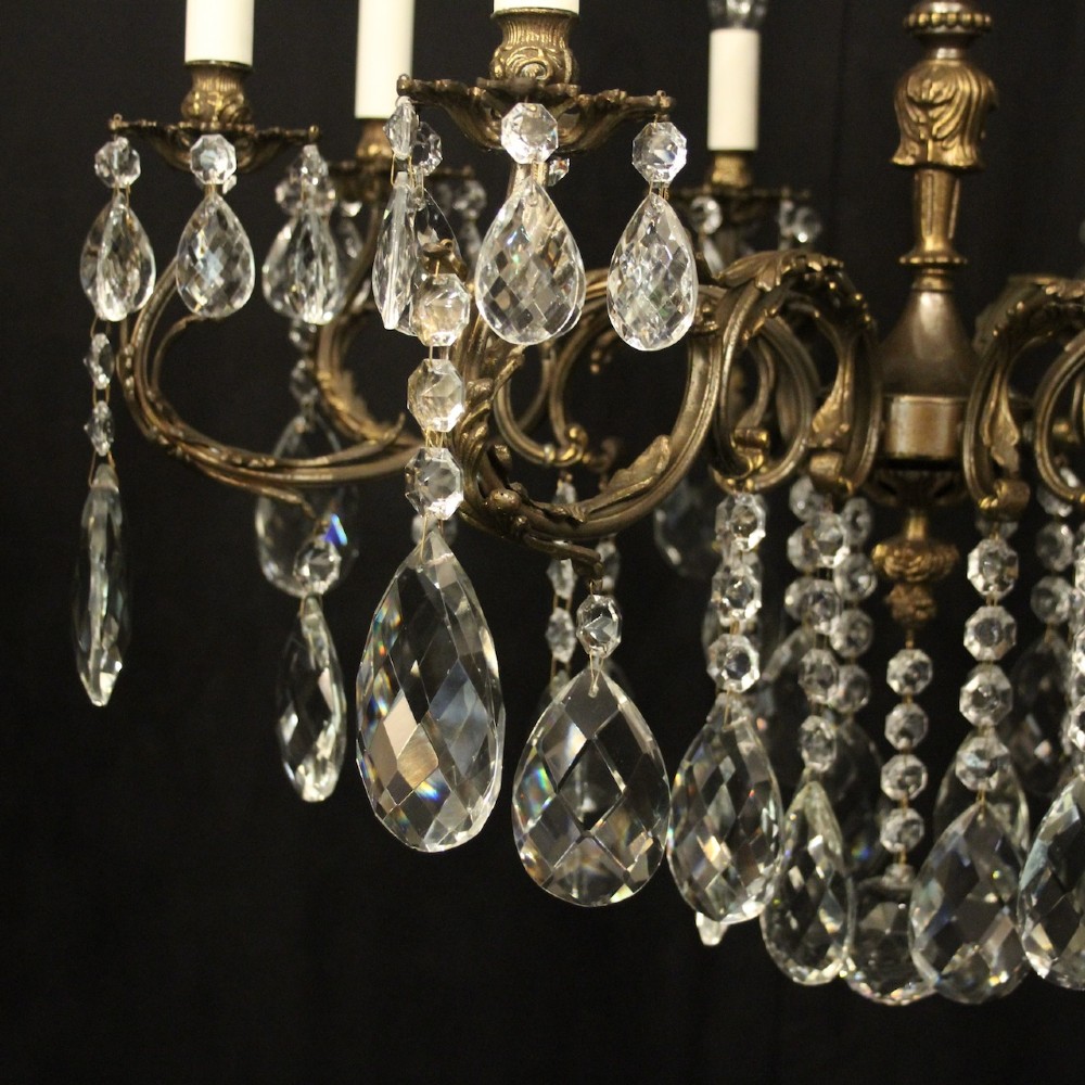 A pair of antique French eight-light brass chandeliers featuring scrolled arms and cut crystal teardrop prisms. View IV