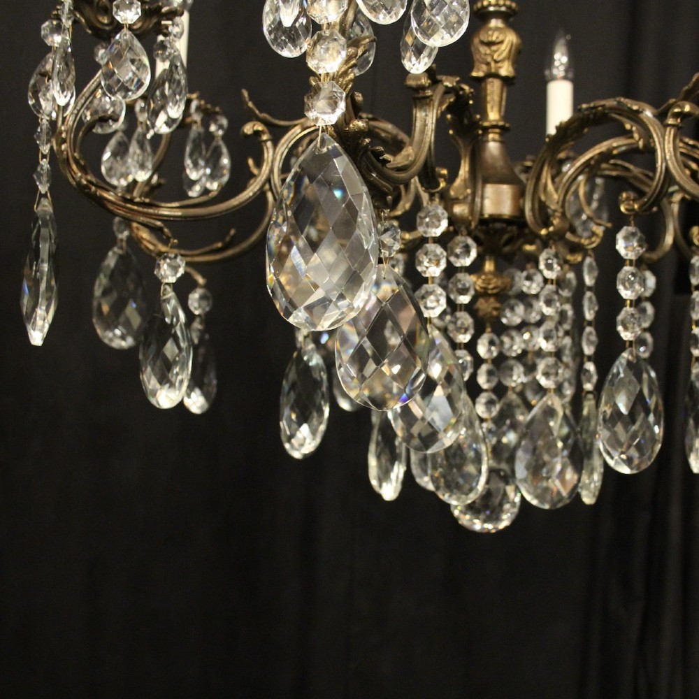 A pair of antique French eight-light brass chandeliers featuring scrolled arms and cut crystal teardrop prisms. View V