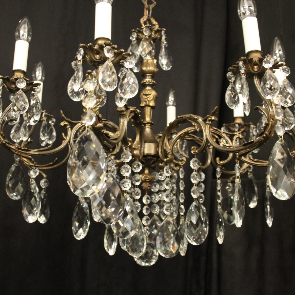 A pair of antique French eight-light brass chandeliers featuring scrolled arms and cut crystal teardrop prisms. View VI