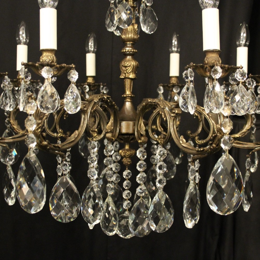 A pair of antique French eight-light brass chandeliers featuring scrolled arms and cut crystal teardrop prisms. View VII