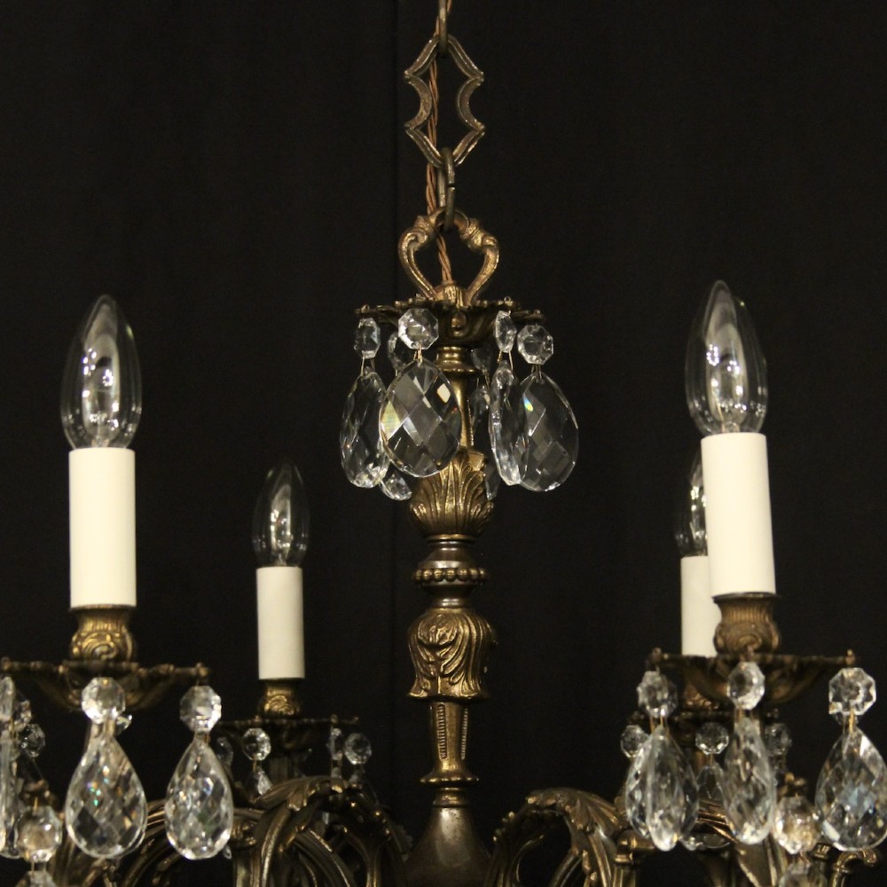 A pair of antique French eight-light brass chandeliers featuring scrolled arms and cut crystal teardrop prisms. View VIII
