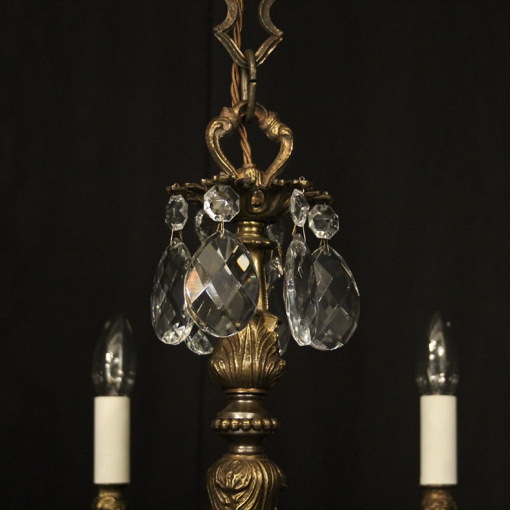A pair of antique French eight-light brass chandeliers featuring scrolled arms and cut crystal teardrop prisms. View IX