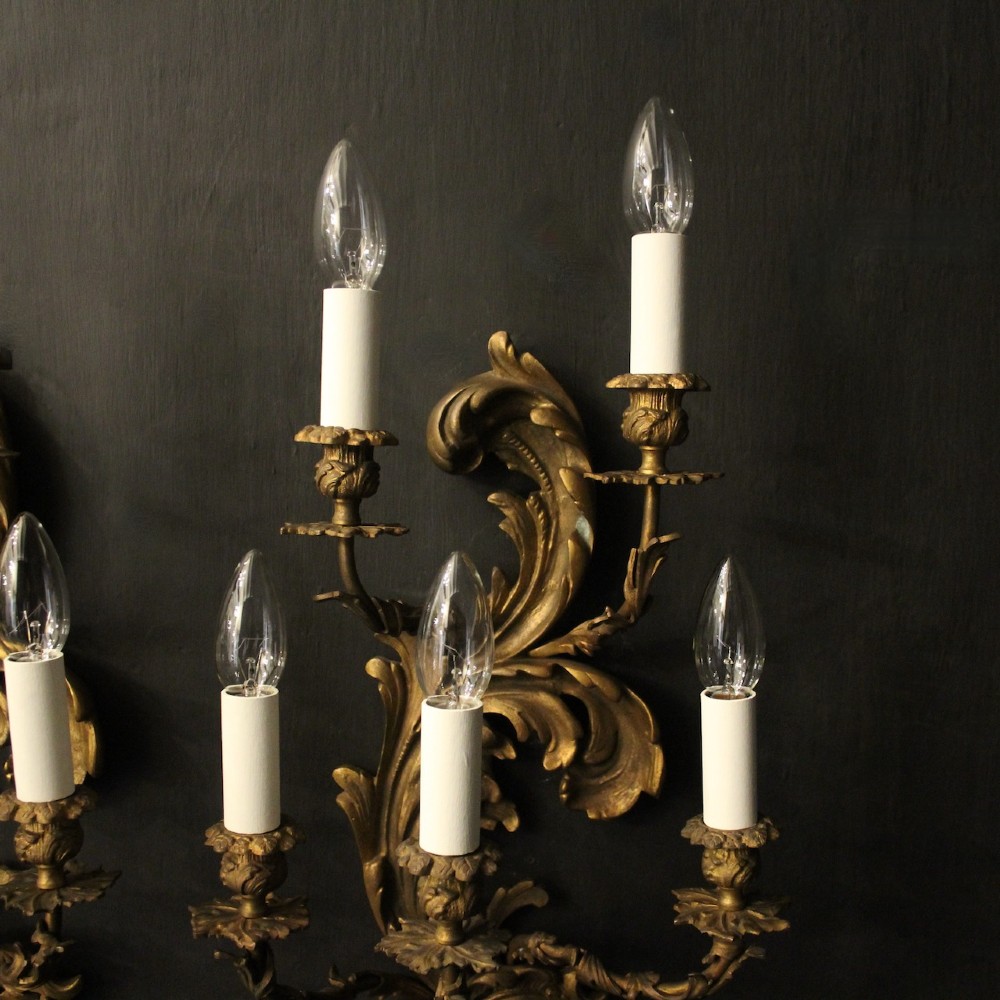 A pair of ornate French Rococo style gilded bronze five-arm wall sconces featuring acanthus leaf scrollwork. View IV