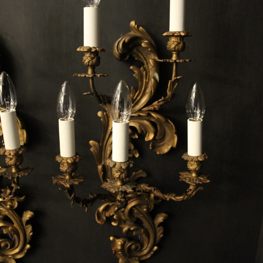 A pair of ornate French Rococo style gilded bronze five-arm wall sconces featuring acanthus leaf scrollwork. View V