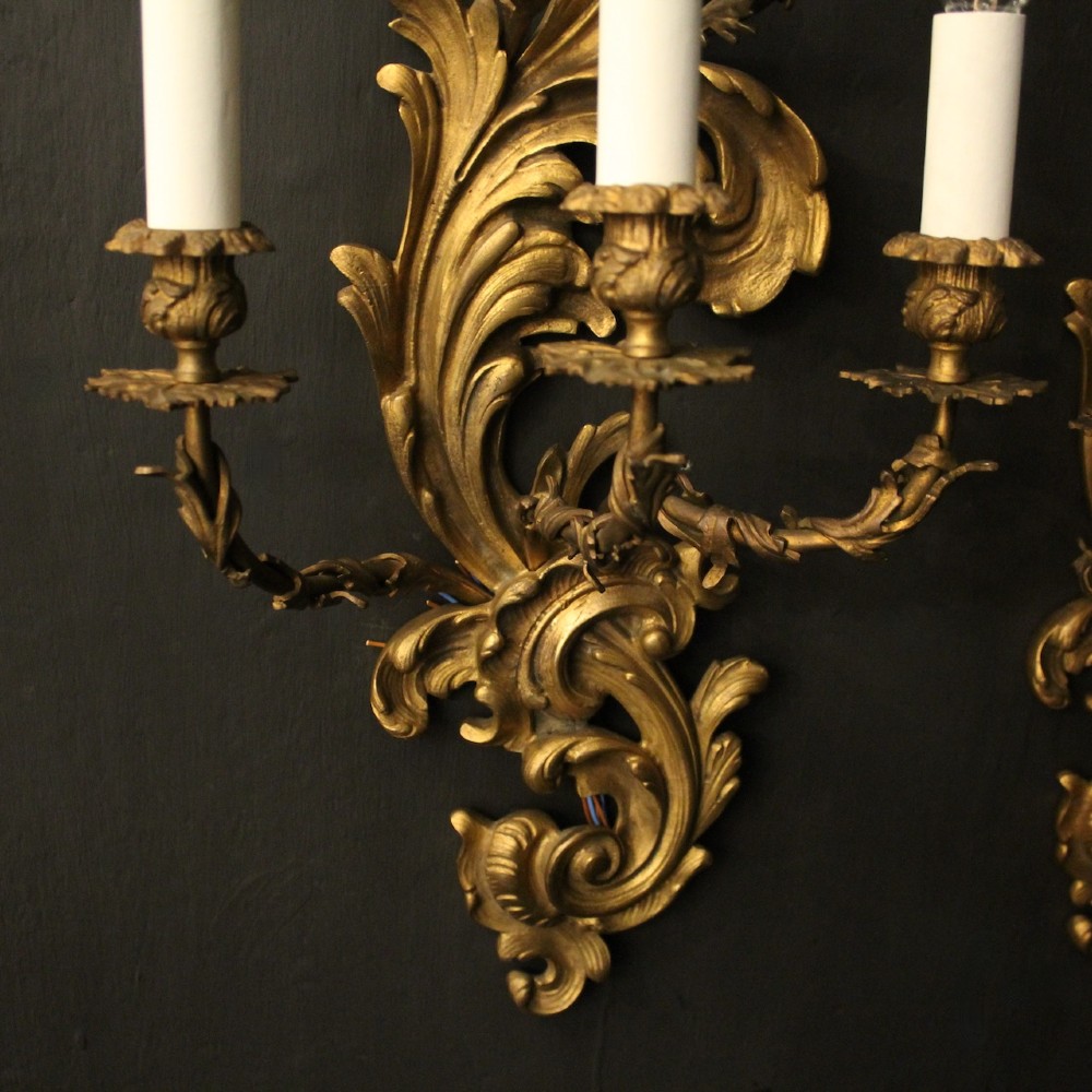 A pair of ornate French Rococo style gilded bronze five-arm wall sconces featuring acanthus leaf scrollwork. View IX