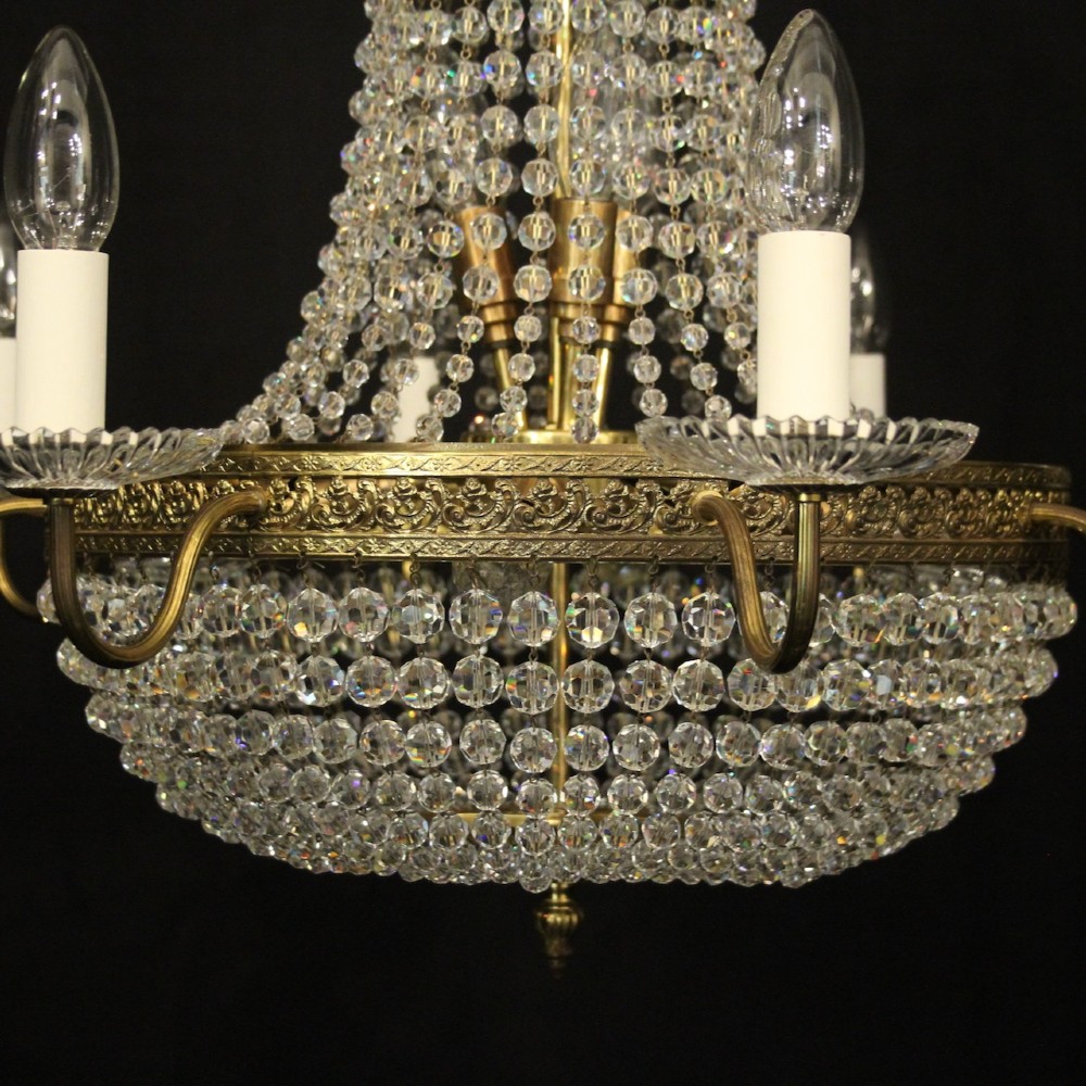 A French gilded brass fifteen-light waterfall chandelier featuring cascading crystal beads, a detailed metal gallery band, and radiating candle arms. View II