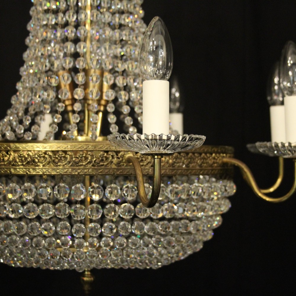 A French gilded brass fifteen-light waterfall chandelier featuring cascading crystal beads, a detailed metal gallery band, and radiating candle arms. View III
