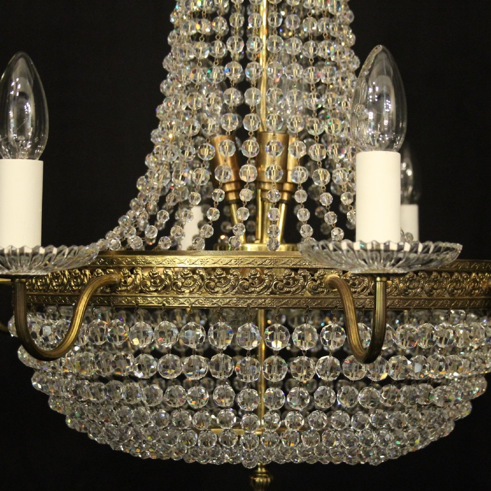 A French gilded brass fifteen-light waterfall chandelier featuring cascading crystal beads, a detailed metal gallery band, and radiating candle arms. View IV