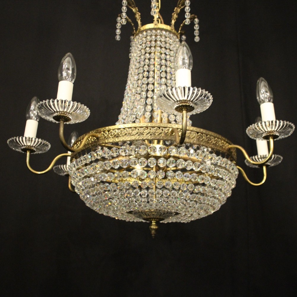 A French gilded brass fifteen-light waterfall chandelier featuring cascading crystal beads, a detailed metal gallery band, and radiating candle arms. View V
