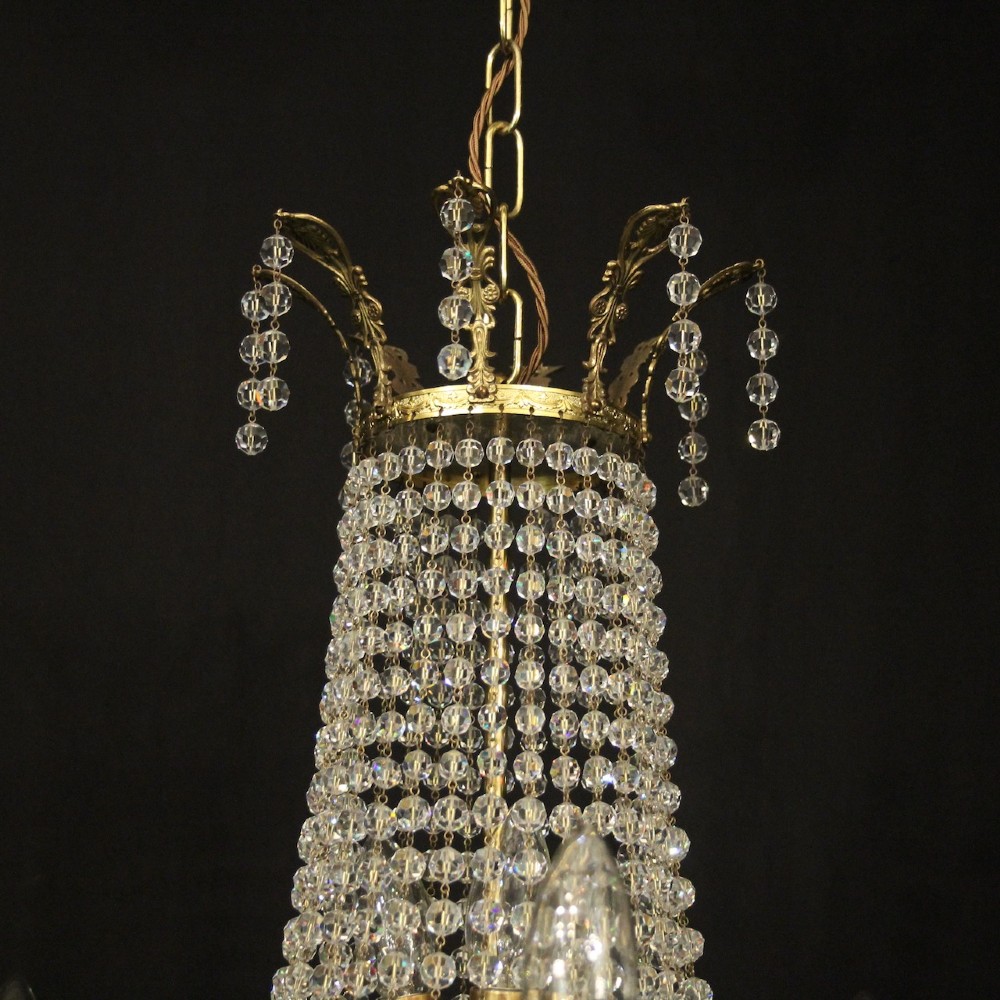 A French gilded brass fifteen-light waterfall chandelier featuring cascading crystal beads, a detailed metal gallery band, and radiating candle arms. View VIII