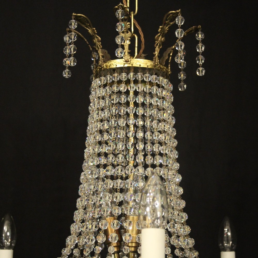 A French gilded brass fifteen-light waterfall chandelier featuring cascading crystal beads, a detailed metal gallery band, and radiating candle arms. View IX