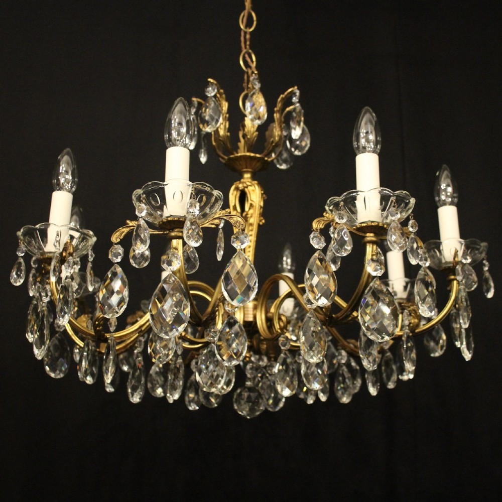 An eight-arm French chandelier featuring a gilded brass frame decorated with hanging cut-crystal glass drops and white candle-style bulb holders. View II