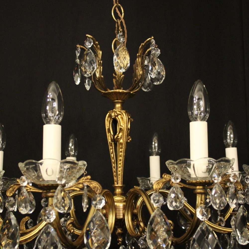 An eight-arm French chandelier featuring a gilded brass frame decorated with hanging cut-crystal glass drops and white candle-style bulb holders. View VIII