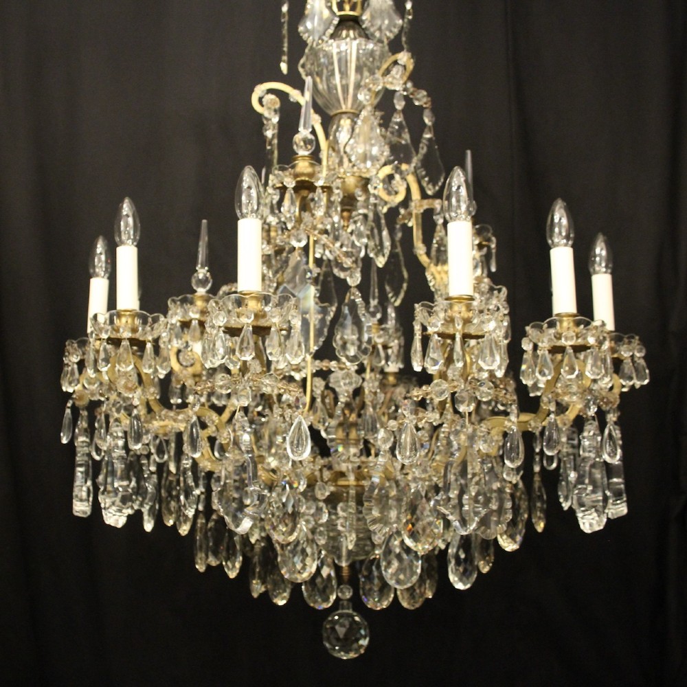 A large French antique twelve-light chandelier featuring a gilded frame dressed with cut crystal teardrop pendants and central glass pinnacles. View III