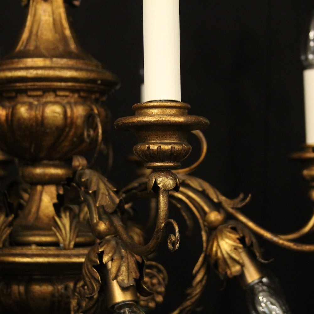 A multi-arm Florentine carved giltwood chandelier featuring leaf scroll detailing and candle sockets. View IV