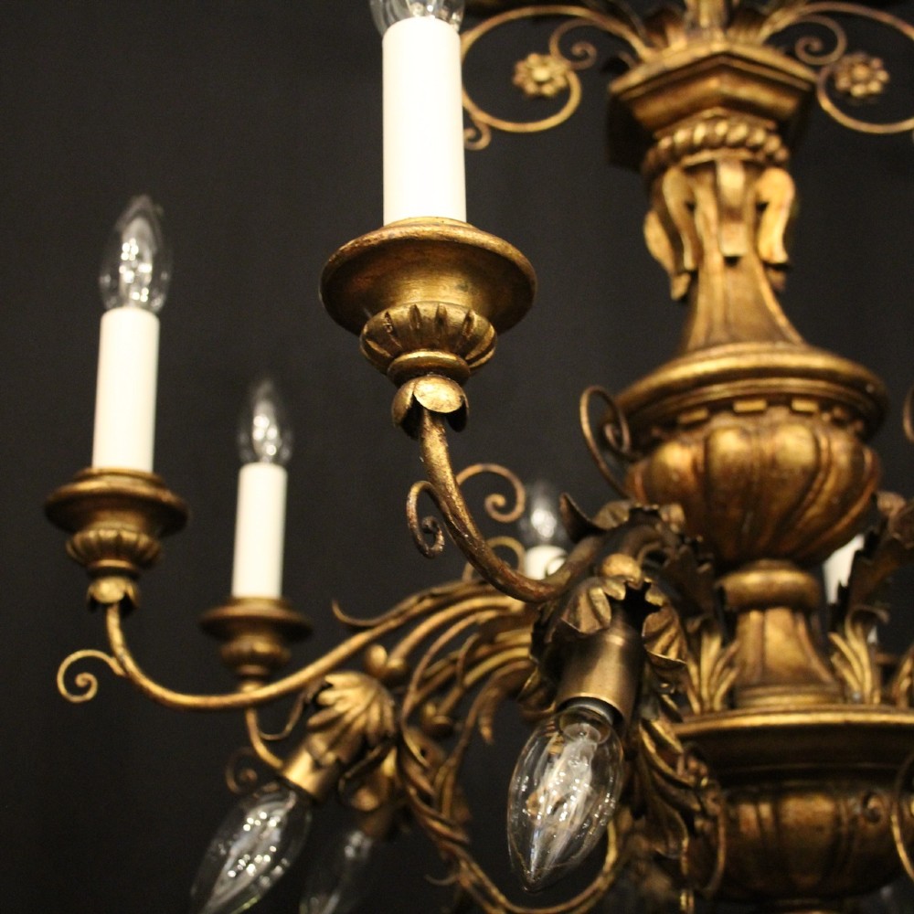 A multi-arm Florentine carved giltwood chandelier featuring leaf scroll detailing and candle sockets. View V