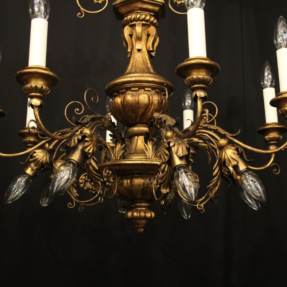 A multi-arm Florentine carved giltwood chandelier featuring leaf scroll detailing and candle sockets. View VI
