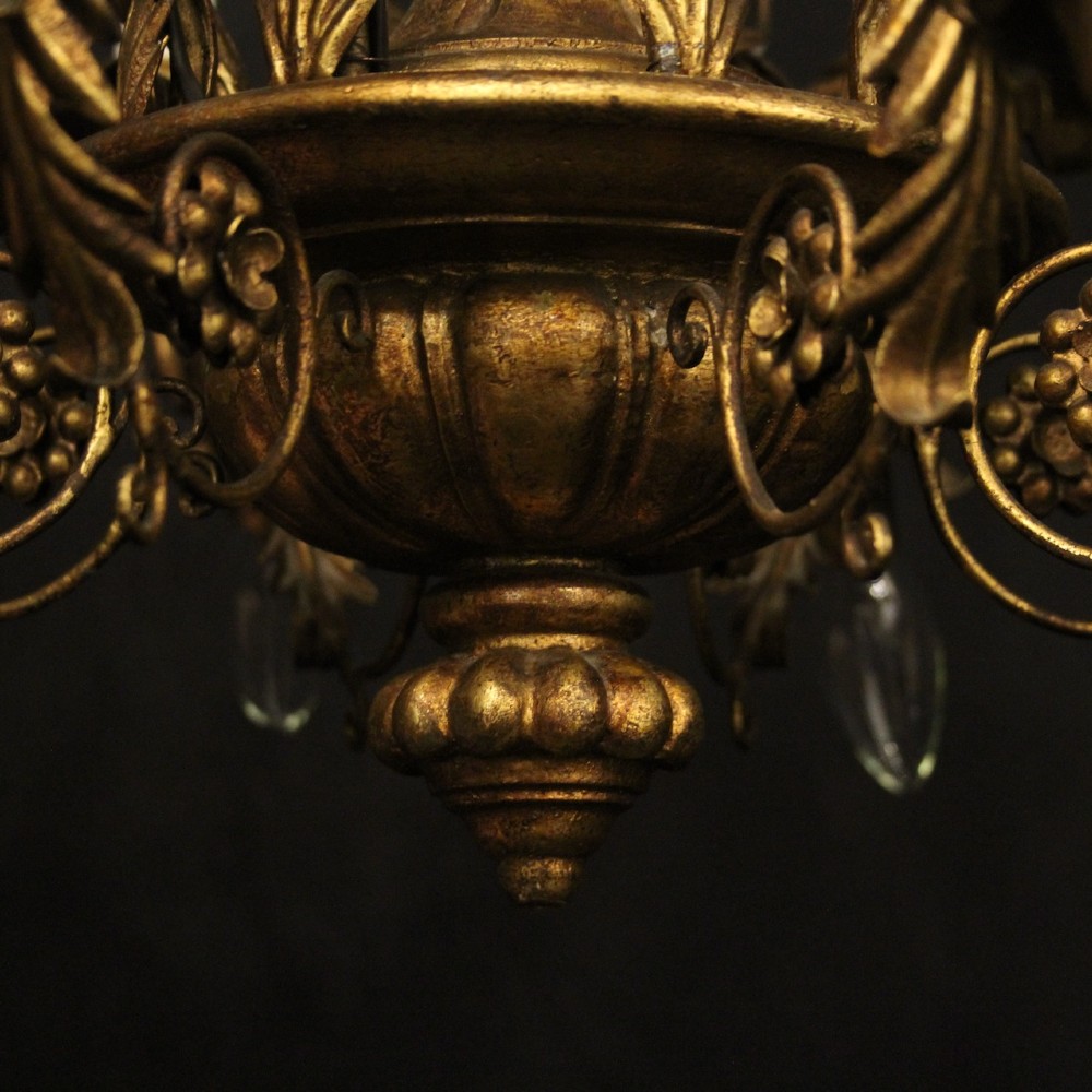 A multi-arm Florentine carved giltwood chandelier featuring leaf scroll detailing and candle sockets. View VII