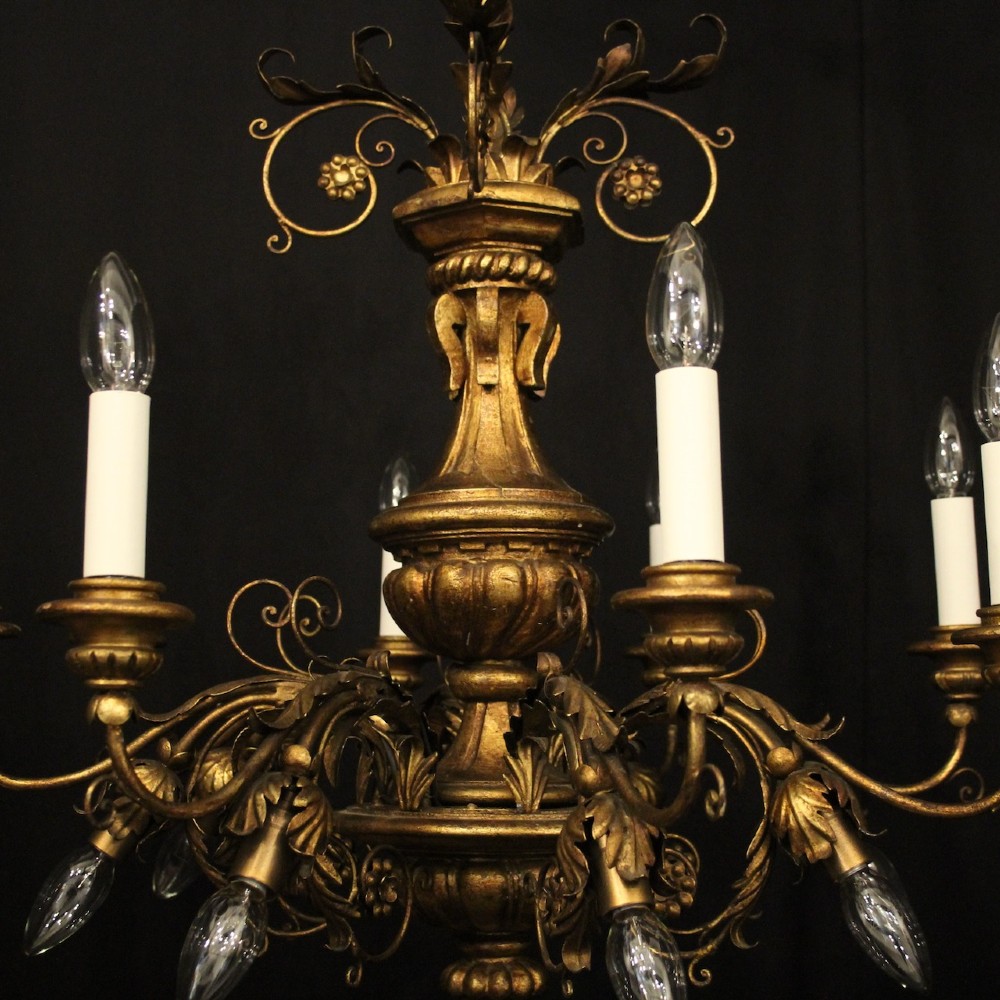 A multi-arm Florentine carved giltwood chandelier featuring leaf scroll detailing and candle sockets. View VIII