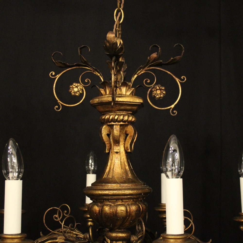 A multi-arm Florentine carved giltwood chandelier featuring leaf scroll detailing and candle sockets. View IX