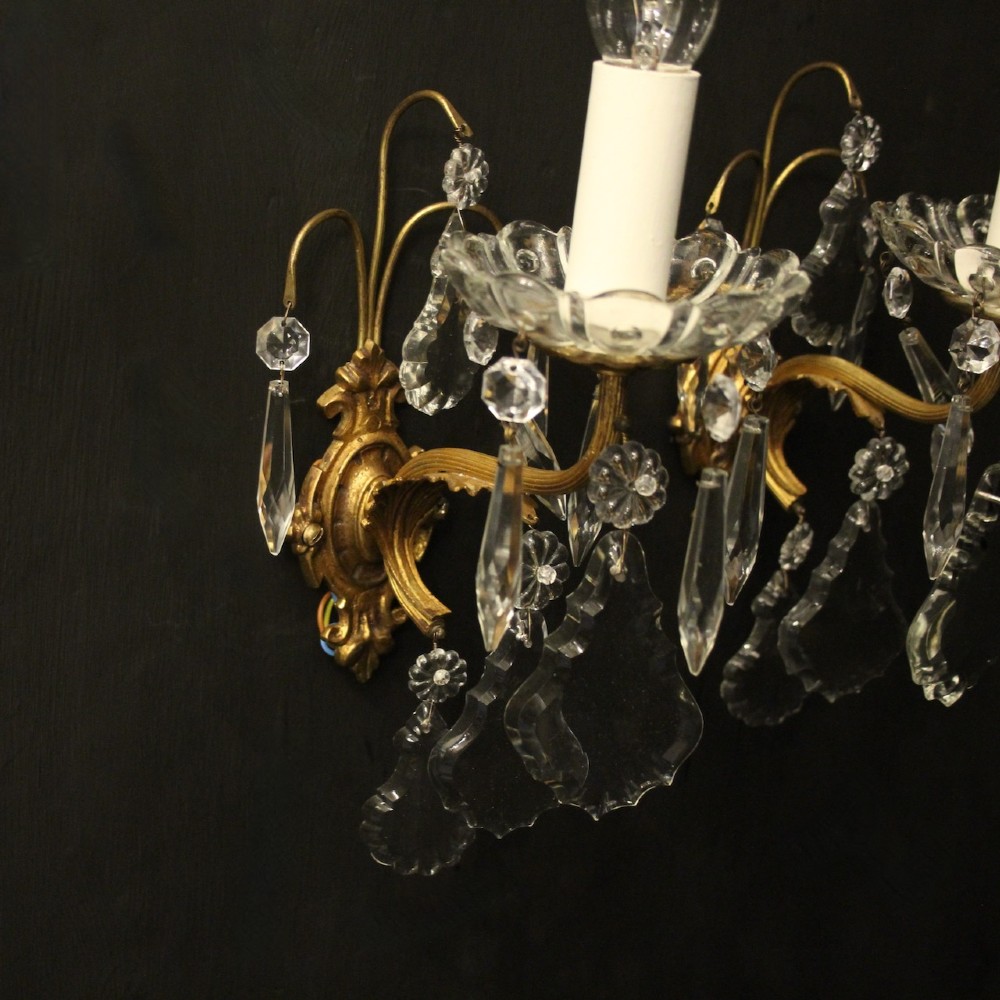 A pair of French gilded single-arm wall lights featuring clear crystal drops and scalloped glass drip pans. View IV