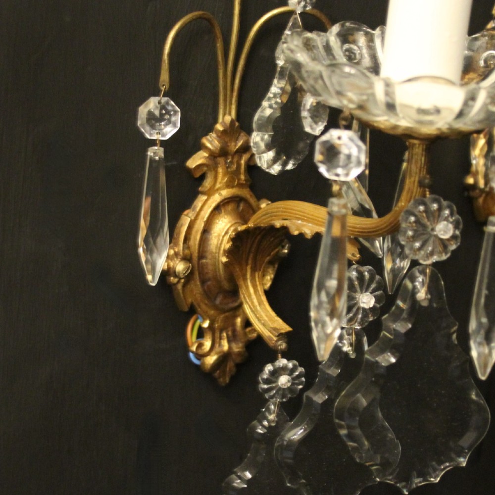 A pair of French gilded single-arm wall lights featuring clear crystal drops and scalloped glass drip pans. View V