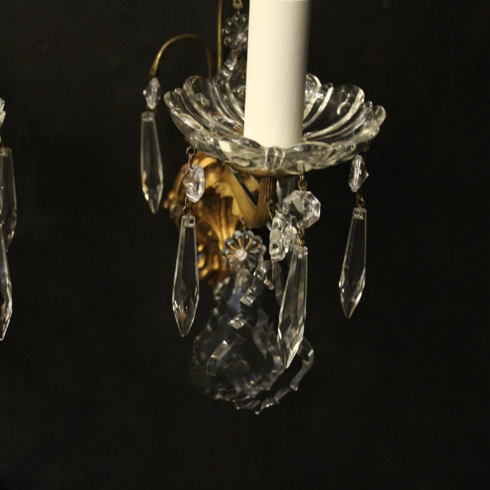 A pair of French gilded single-arm wall lights featuring clear crystal drops and scalloped glass drip pans. View VIII