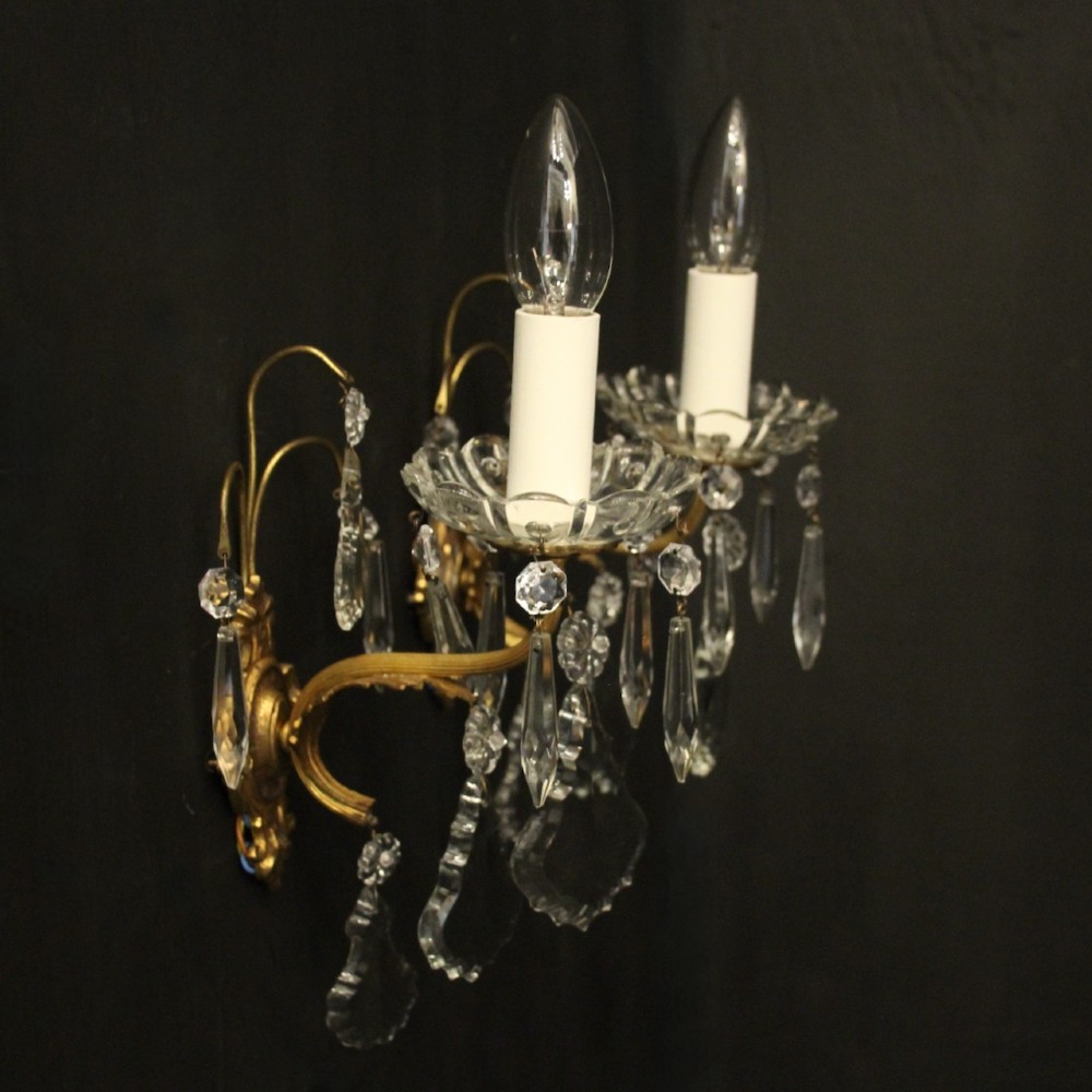 A pair of French gilded single-arm wall lights featuring clear crystal drops and scalloped glass drip pans. View IX