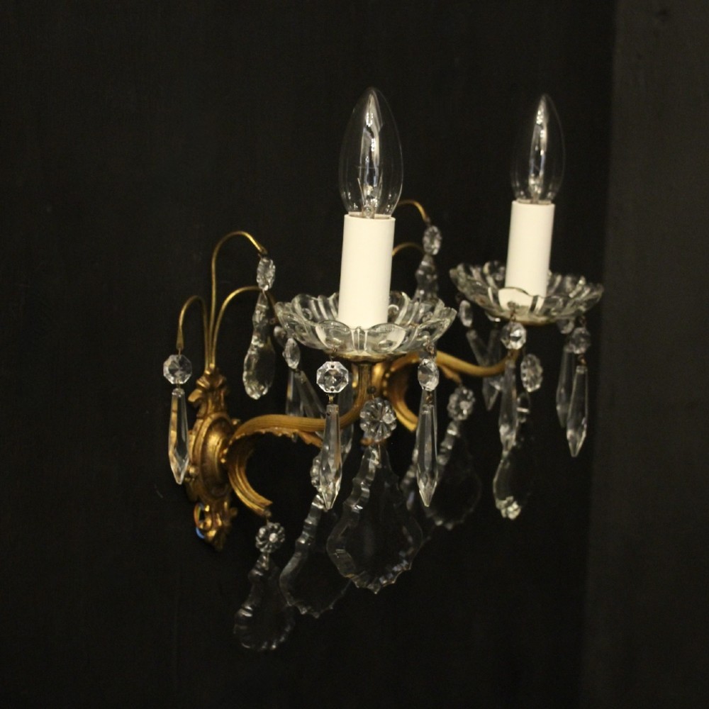 A pair of French gilded single-arm wall lights featuring clear crystal drops and scalloped glass drip pans. View X