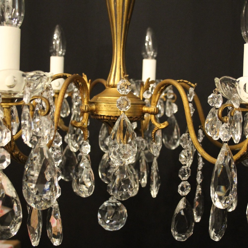 A French gilded brass five-arm chandelier decorated with hanging crystal teardrops and white candle sleeves. View VII